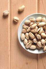 Pistachio nuts on a wooden table.
