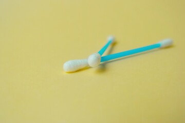 Cotton sticks ear blue plastic on a yellow background. Personal hygiene and care. Cosmetology and medicine.
