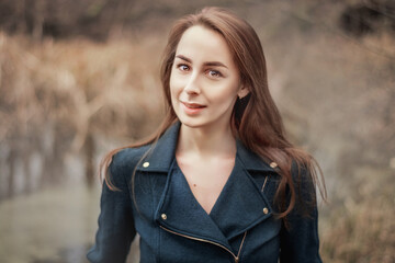 Portrait of a beautiful young woman in the autumn forest. The girl looks up and smiles. Autumn forest
