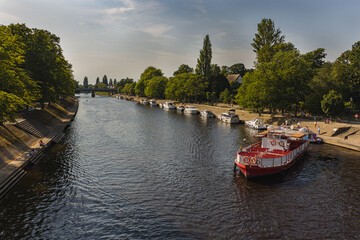 River by the city at sunset with tourist boat. River Ouse, York, UK.