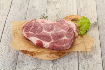 Raw pork steak over wooden board