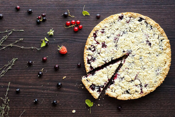 Homemade shortbread berry pie with a slice cut off on wooden table texture. Summer photo receipts