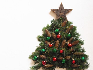Christmas card.Christmas tree made of fir branches with a wooden star, Christmas tree cones and Christmas balls on a white background.