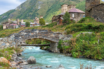 Fototapeta na wymiar Traditional medieval Svanetian tower houses, Stone bridge over Patara Enguri River, Ushguli village, Svaneti region, Caucasus, Georgia