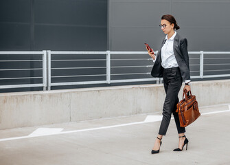 A business woman checks the time in the city during a working day waiting for a meeting. Discipline and timing. An employee goes towards a corporate meeting.
