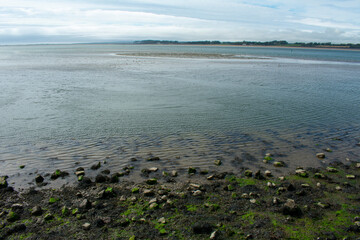 The royal town of Caernarfon, Wales. View from the sand flats at the waters edge, over the bay to the island of Anglesey.