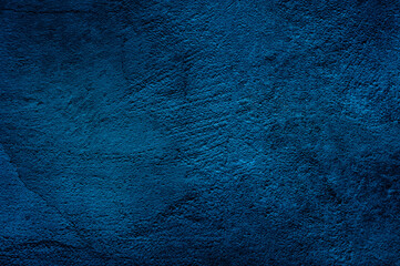 Dark blue saturated wall texture background.Structural plaster wall with cracks, colored to dark blue color. Saturated blue colour trend of the 2020 year. Abstract background texture pattern,copyspace
