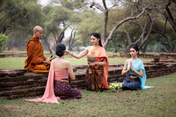 Thai woman pay homage to a Buddhist monk in morning.