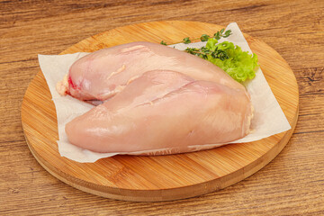 Raw chicken breast over board
