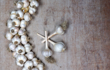 Fresh Harvesting garlic from out of  the garden. braided garlic or Garlic string. Harvested vegetables, organic. Decorative food at wooden background.