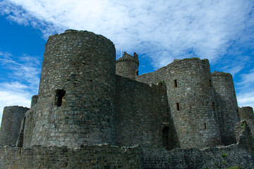 Fototapeta na wymiar Wales, the historic seaside town of Harlech. The imposing medieval castle with dramatic towers and austere defensive walls. Blue skies on a summers day - copy space.