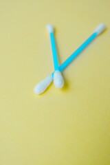 Cotton sticks ear blue plastic on a yellow background. Personal hygiene and care. Cosmetology and medicine.