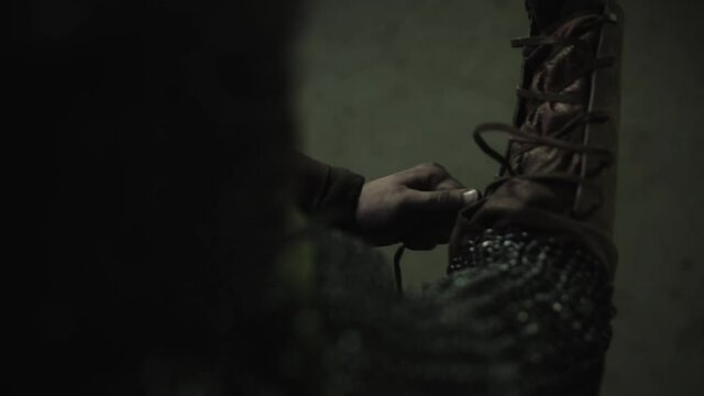 Warrior wearing up his bracers. Camera perspective left to ride shoulder from back