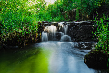 blurred image of a small river waterfall close-up.