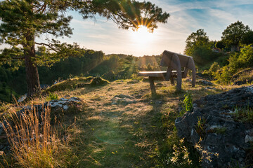 Bench on rock hillside of Franconian Switzerland, sunset on summer evening