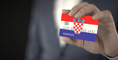 Businessman takes plastic bank card with printed flag of Croatia, close-up shot, fictional numbers