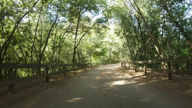 Point of view shot of riding a bicycle at Amarante Cycling Trail in Portugal. Features a wide view of the bike track and the natural scenery as it travels.