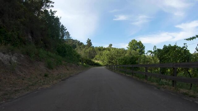Point of view shot of riding a bicycle at Amarante Cycling Trail in Portugal. Features a wide view of the bike track and the natural scenery as it travels.