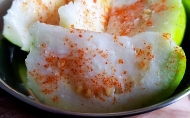 Green crystal guava raw fruit and sliced with sprinkle chilli powder. Sweet green guava One of the most gregarious fruit with red chilly powder, Latin name Psidium Guajava