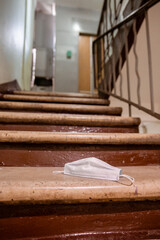 White mask from the Covid-19 or Corona virus is littering on stairs
