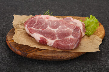 Raw pork steak over wooden board