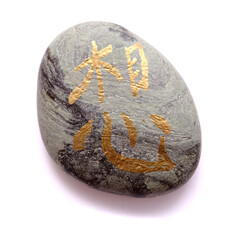 Chinese or Japanese symbol meaning think or miss, painted on volcanic pebbles in metallic paint