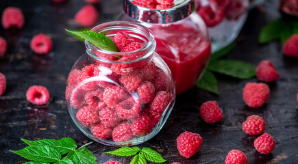 Glass jars with raspberries in different forms. Fresh, frozen, and pureed. Concept of storage types of berries