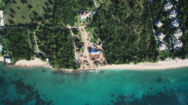 Top-down view of dense forest and rooftops on the seashore in Saint Kitts and Nevis