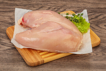 Raw chicken breast over board