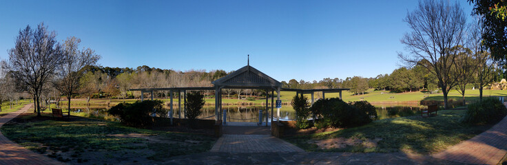 Beautiful morning view of a beautiful structure along the pond in a park with deep blue sky and tall trees, Fagan park, Galston, Sydney, New South Wales, Australia