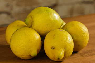 Mehrere natürliche Bio-Zitronen in bäuerlich-rustikaler Umgebung