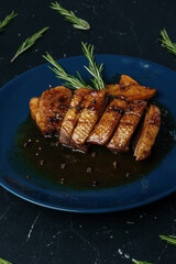 Marinated duck breast with orange sauce and 
rosemary decoration
