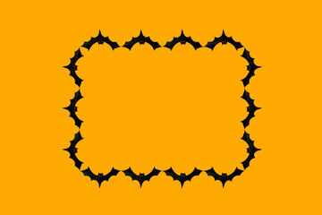 Paper cut black bats laid out in the form of a frame on an orange background, space for text, halloween concept