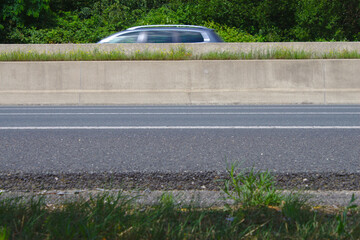 Autobahn mit Auto und Betonwand