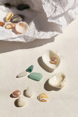 Fototapeta na wymiar seashells, pearls, stones, colored glass on a white background