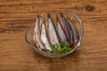 Anchovies in the bowl served basil leaves