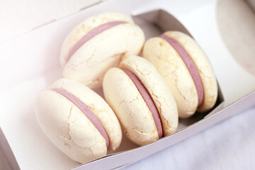White macaroons in a cardboard box, dessert.