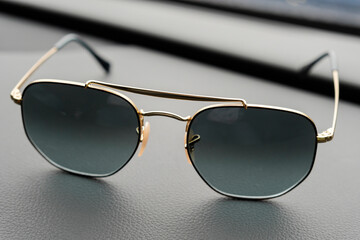 Fashionable sunglasses. Sunglasses with mirrored lenses on leather table. Mirrored sunglasses with anti-reflective coating.