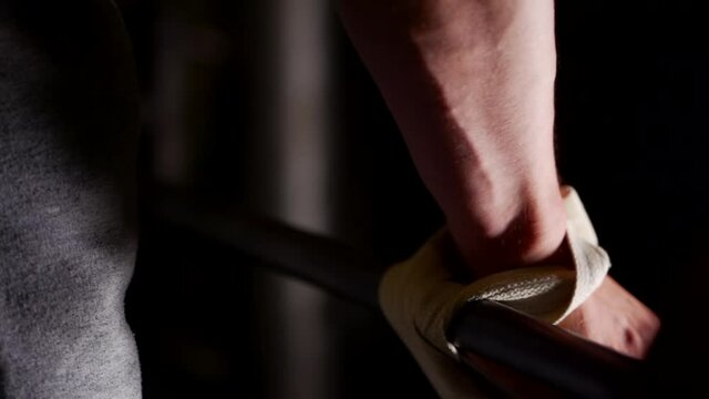 the man winds the wrist strap on the bar neck. close-up of the hand