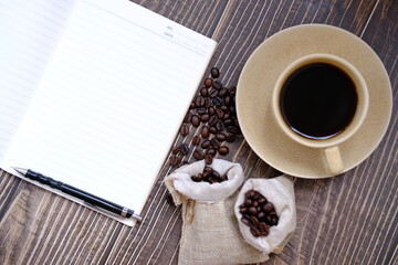 cup of coffee and coffee beans on table background