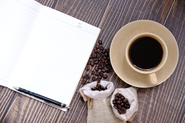 coffee cup and coffee beans on old wood table background, space for text