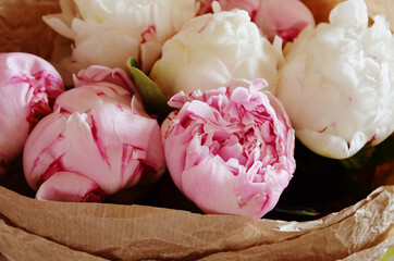 Pink and white peonies in craft paper