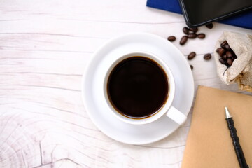 coffee cup and coffee beans on old wood table background, space for text