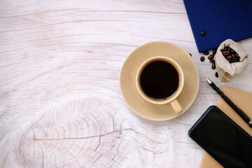 Top view cup of coffee and coffee beans on table background