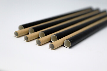 Brown and black drinking paper straws on a white background