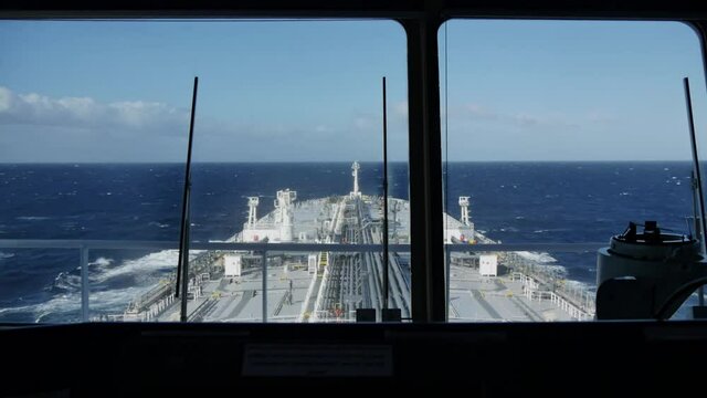 Grey oil tanker is underway at sea. Shooting from bridge