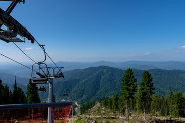 cable car chair lift in the mountains. climbing the mountain on a lift. view from the top of the...