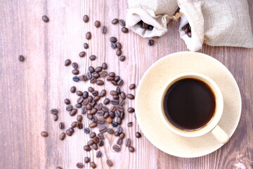 Top view cup of coffee and coffee beans on table background