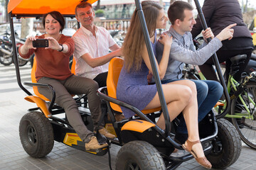 family of tourists enjoy a walk on the bike carriage