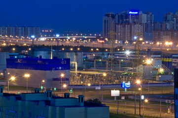 Evening lights of St. Petersburg at night during the white nights. View of the road bridge and power station.